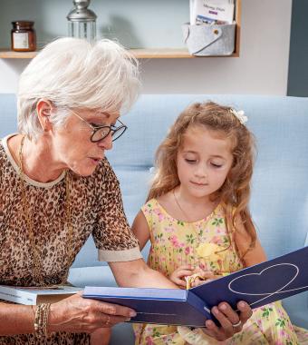 petite fille et sa grand mère avec un album souvenirs